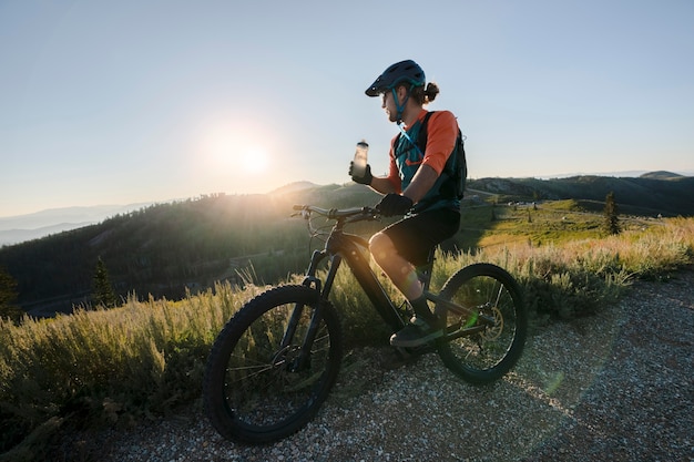 Jeune adulte à l'aide de vélo électrique à la campagne