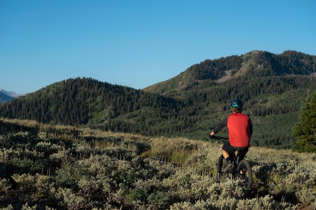 Photo gratuite jeune adulte à l'aide de vélo électrique à la campagne