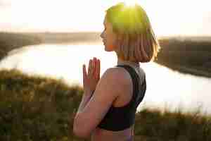 Photo gratuite jeune adulte appréciant le yoga dans la nature