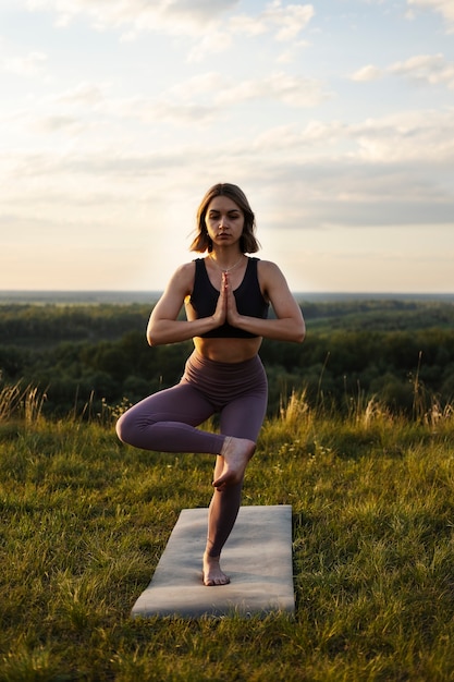 Photo gratuite jeune adulte appréciant le yoga dans la nature