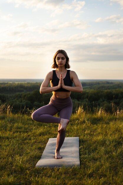 Jeune adulte appréciant le yoga dans la nature