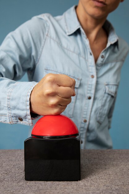 Jeune adulte en appuyant sur le bouton buzzer