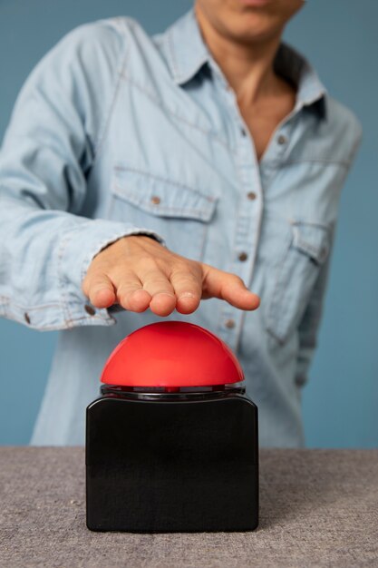 Jeune adulte en appuyant sur le bouton buzzer