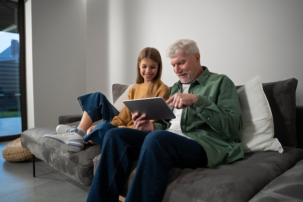 Photo gratuite jeune adulte enseignant à une personne âgée l'appareil numérique