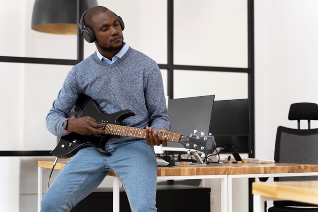 Jeune adulte jouant de la guitare