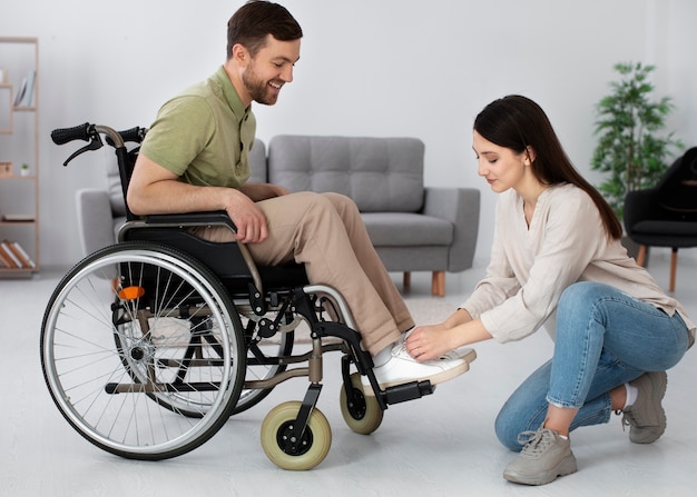 Jeune adulte prenant soin d'un ami handicapé