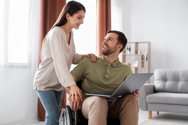 Jeune adulte regardant une émission de télévision avec un ami handicapé