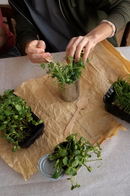 Jeune adulte réutilisant des canettes pour la plantation