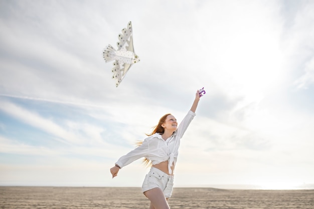 Photo gratuite jeune adulte s'amusant avec le cerf-volant