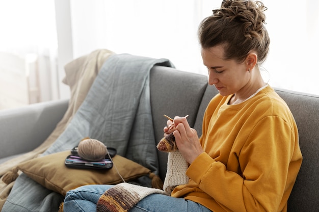 Photo gratuite jeune adulte se détendre en tricotant