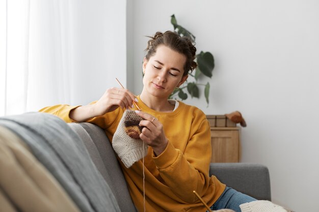 Jeune adulte se détendre en tricotant