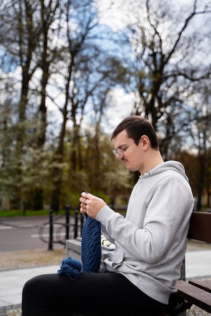 Jeune adulte tricotant à l'extérieur