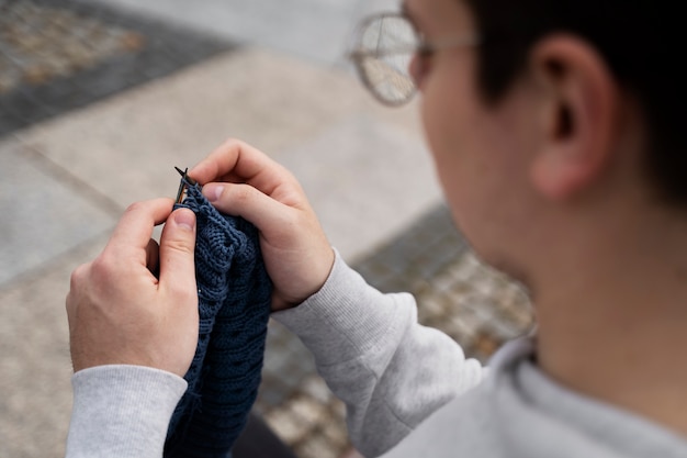 Jeune adulte tricotant à l'extérieur