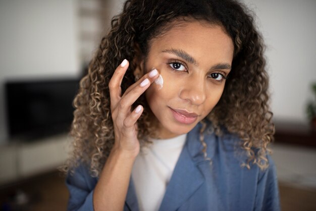 Jeune adulte utilisant un produit de soin du visage