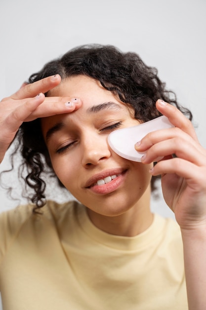 Jeune adulte utilisant un produit de soin du visage