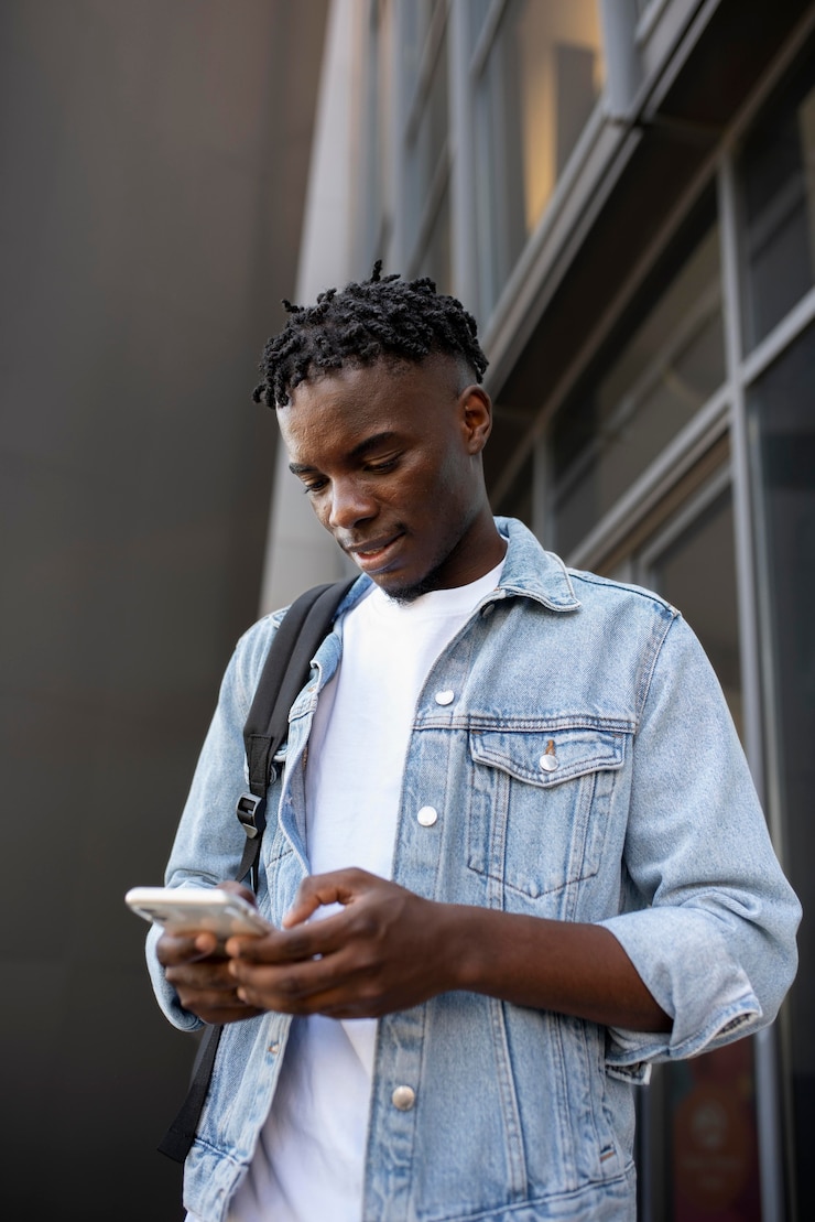 Photo gratuit jeune adulte utilisant son appareil numérique