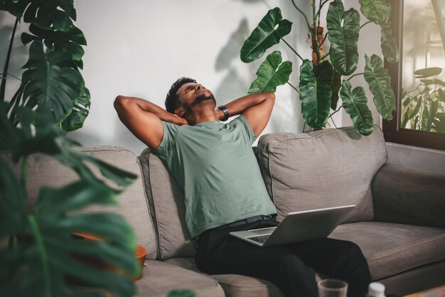 Jeune afro-américain pigiste souffrant de maux de tête après avoir travaillé dur avec un ordinateur portable travail à domicile concept de soins de santé mentale