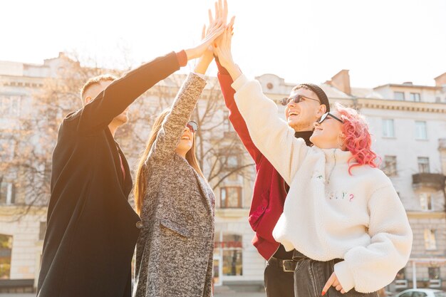 Jeune ami soulevant des mains empilées