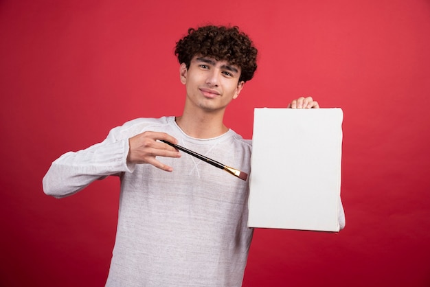 Jeune artiste au pinceau et toile.