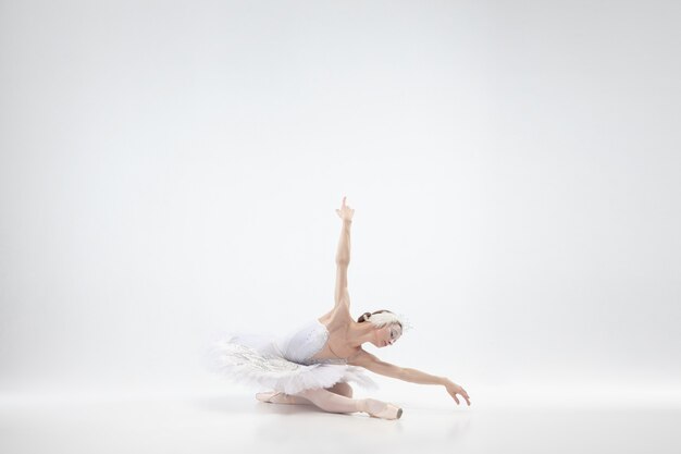 Jeune ballerine gracieuse sur fond de studio blanc