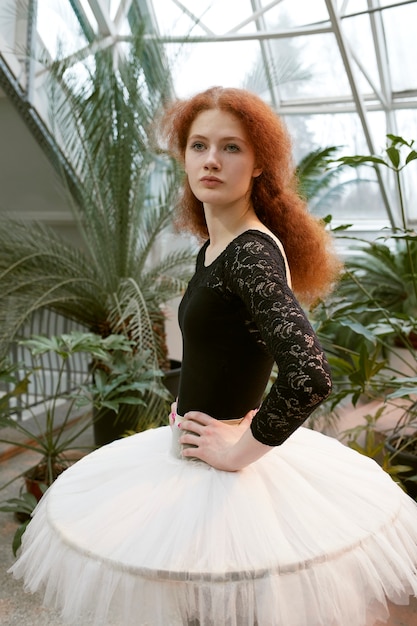 Jeune ballerine posant à l'intérieur dans un jardin botanique