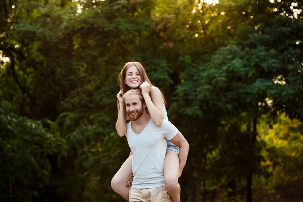 Jeune beau couple au repos, marchant dans le parc, souriant, se réjouissant.