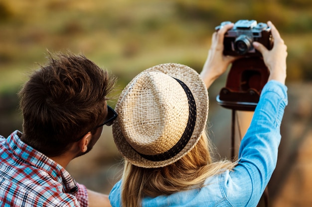 Jeune beau couple faisant selfie sur vieil appareil photo, fond de canyon