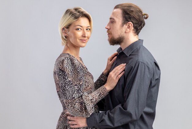 Jeune beau couple homme et femme heureux en amour ensemble célébrant la Saint-Valentin debout sur un mur blanc