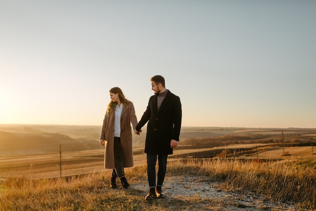 Jeune et beau couple marchant à l'extérieur par une journée ensoleillée