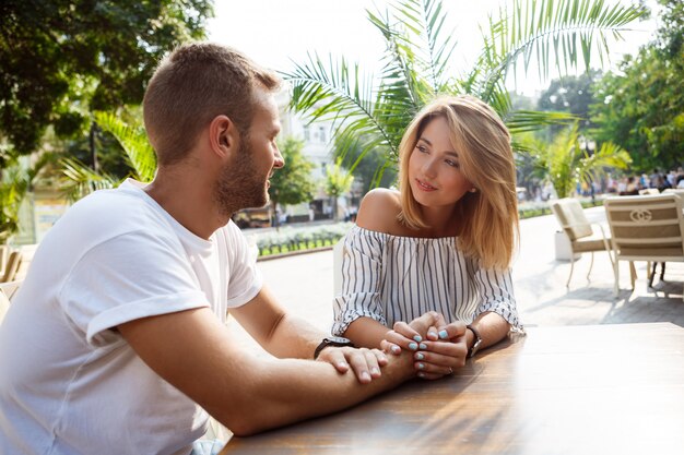 Jeune beau couple parlant, souriant, se reposant au café.