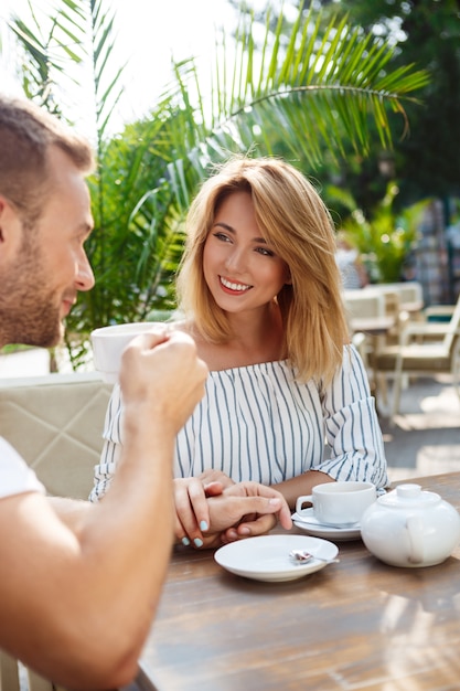 Jeune beau couple parlant, souriant, se reposant au café.