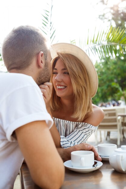 Jeune beau couple parlant, souriant, se reposant au café.