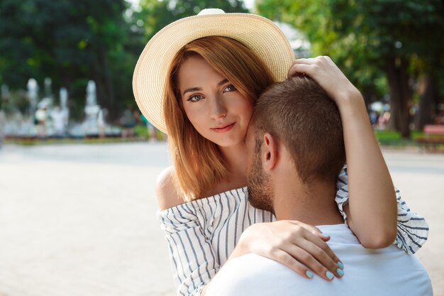 Jeune beau couple souriant, embrassant, marchant dans le parc.