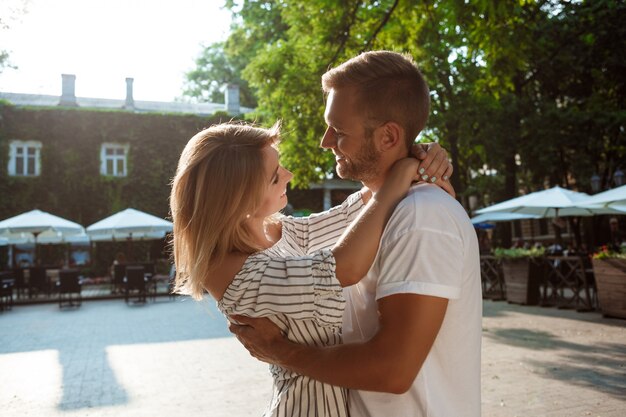 Jeune beau couple souriant, embrassant, marchant dans le parc.