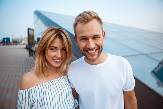 Jeune beau couple souriant, embrassant, se promenant dans la ville