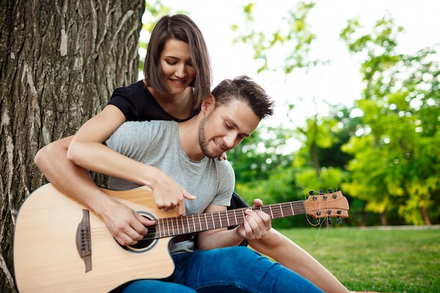 Jeune beau couple souriant, reposant sur un pique-nique dans le parc.