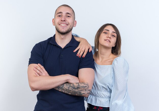 Jeune beau couple en vêtements décontractés homme et femme à la recherche de sourire gaiement debout