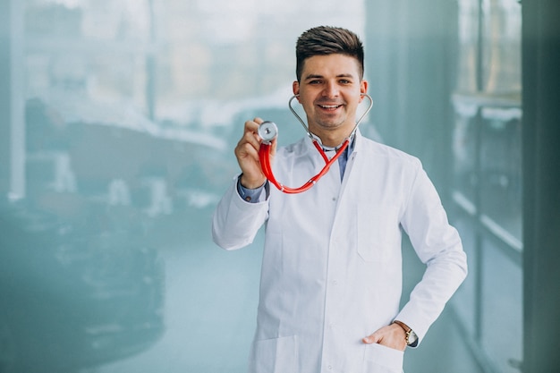 Jeune beau médecin dans un peignoir médical avec stéthoscope