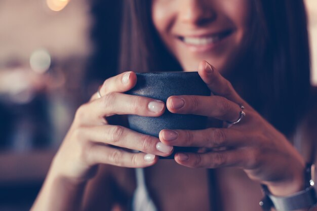 Jeune beauté femme buvant du café au café, portrait heureux en plein air