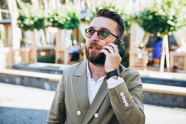 Jeune bel homme d'affaires à l'aide de téléphone