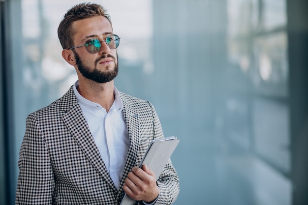 Jeune bel homme d'affaires au bureau tenant la tablette