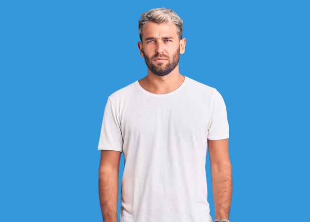 Jeune bel homme blond portant un t-shirt décontracté déprimé et inquiet pour la détresse pleurant en colère et effrayé expression triste