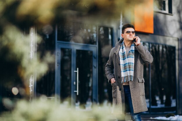 Jeune bel homme à l'extérieur à l'aide de téléphone