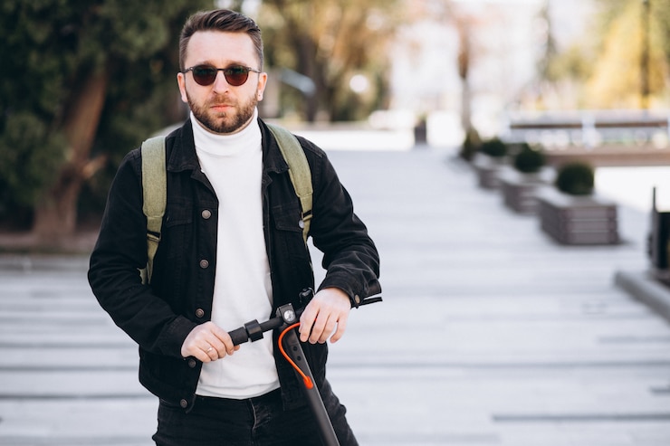Photo gratuit jeune bel homme monté sur scooter dans le parc