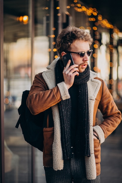 Jeune bel homme parlant au téléphone près de l'aéroport