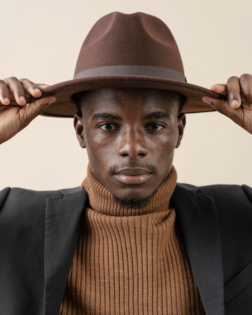 Jeune bel homme posant avec chapeau