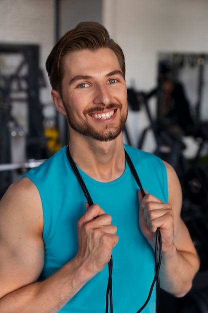 Photo gratuite jeune bel homme s'entraînant au gymnase pour la musculation