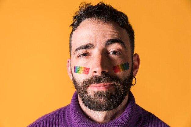 Jeune bel homme avec symbole LGBT sur le visage