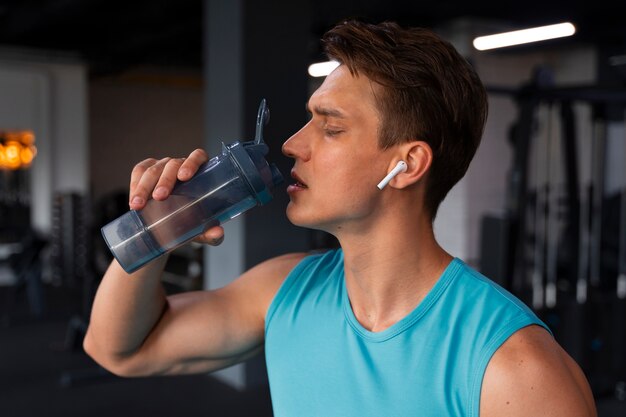 Jeune bel homme travaillant au gymnase pour la musculation