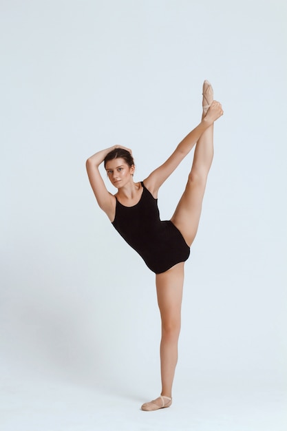 Jeune belle danseuse contemporaine posant sur mur blanc. Copiez l'espace.